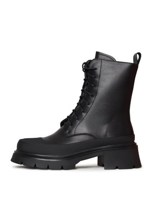 Bottines en cuir noir avec un design à lacets, semelle épaisse et crantée. Dotées d'une languette à l'arrière pour un enfilage facile.