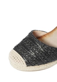 Espadrilles nere intrecciate con una parte superiore texturizzata, suola in juta naturale e punta arrotondata. Il design moderno presenta cuciture a contrasto lungo il bordo.