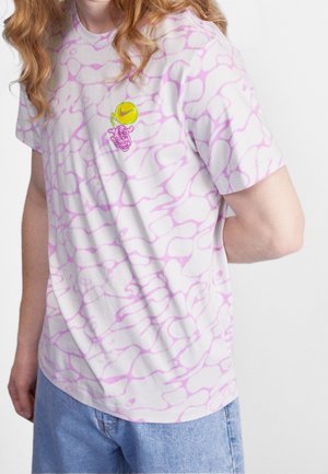 Camiseta blanca con patrón abstracto rosa, de mangas cortas, y un pequeño gráfico púrpura en el pecho que presenta un logo de bola verde.