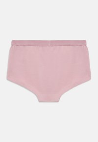 Miękkie różowe bawełniane majtki dla dzieci z elastycznym pasem, płaskimi szwami i prostym wzorem na białym tle.