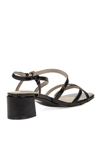 Sandal de charol negro con múltiples correas delgadas, punta redondeada y un tacón bajo cuadrado. Cierre de cremallera en la parte posterior y forro interior suave.