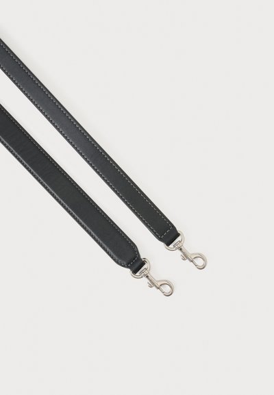 Deux bandoulières en cuir noir avec des fermoirs métalliques argentés sur un fond clair uni.