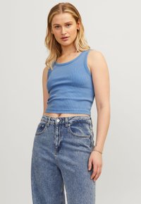 Top cropped azul claro com nervuras e decote redondo, combinado com jeans de ganga azul claro de cintura alta com um design clássico de cinco bolsos.