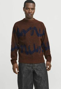 Brauner Strickpullover mit blauem abstraktem Wellenmuster, Rundhalsausschnitt, gerippte Bündchen und Saum, aus weichem Material für Wärme gefertigt.