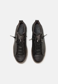 Schwarze Ledersneaker mit strukturierter Oberfläche, elastischen Schnürsenkeln und einer dezent gemusterten Zunge. Verfügt über eine gepolsterte Innensohle für Komfort.