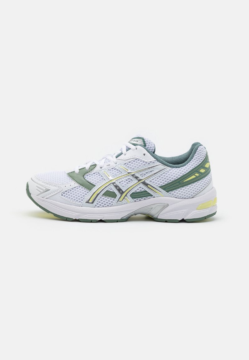Chaussure de course en mesh blanc et vert avec des lacets blancs et des touches jaunes, vue de côté sur un fond blanc uni.