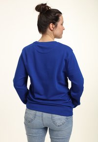 Blaues Sweatshirt mit langen Ärmeln und rundem Halsausschnitt. Weiche Textur, gerippte Bündchen und Saum, mit einfachem Design ohne Muster.