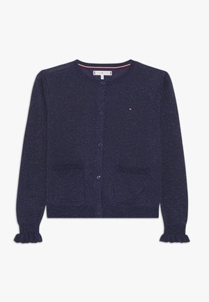 Cardigan boutonné bleu marine à pois avec col rond, deux poches avant, petit logo sur la poitrine et poignets à volants sur manches longues.