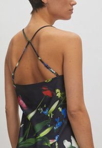 Satin-Blumenslipkleid mit schwarzem Hintergrund, das lebendige rote, rosa und blaue Blumen zeigt. Design mit gekreuztem Rücken und dünnen Trägern.