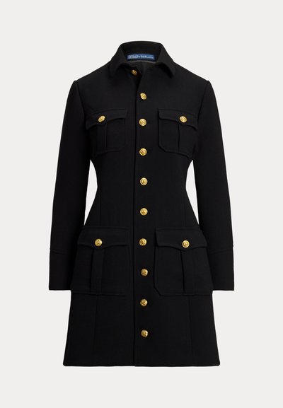 Manteau noir en tissu structuré, avec un col, des boutons dorés, deux poches poitrine et deux poches plaquées inférieures.
