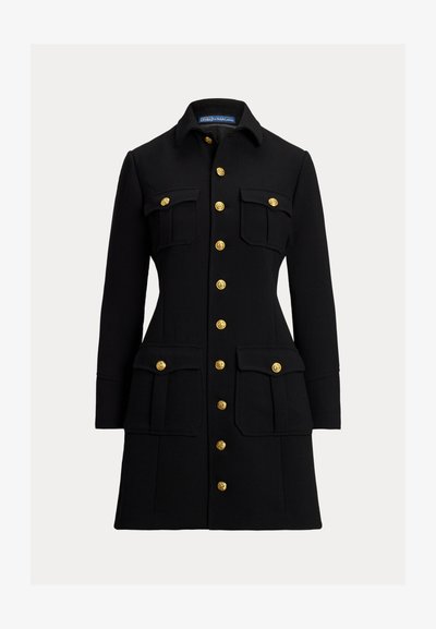 Manteau noir en tissu structuré, avec un col, des boutons dorés, deux poches poitrine et deux poches plaquées inférieures.