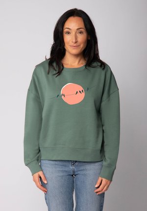 Groene sweatshirt met een ronde, roze grafiek die vogels op een draad afbeeldt. Heeft een relaxte pasvorm, ronde hals en ribgebreide boord en manchetten.