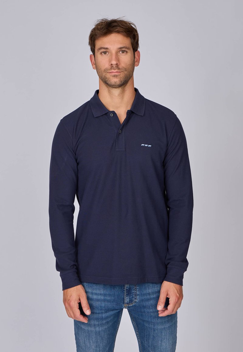 Polo à manches longues navy avec un plastron à boutons et un petit logo bleu sur la poitrine gauche. Matière en coton, coupe régulière, texture minimale.