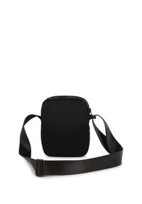 Borsa a tracolla nera in tessuto a rete testurizzato con tracolla removibile e chiusura con zip. Presenta un design minimalista.
