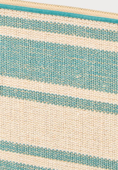 Tissu tissé beige et turquoise avec un motif rayé horizontal et une bordure turquoise le long de la ligne de fermeture éclair en haut.