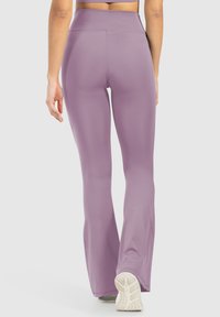 Hooggeplaatste lila yogabroek met een flared ontwerp, gemaakt van rekbaar materiaal, gladde textuur en minimale naden voor comfort.