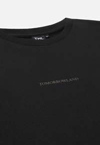 Zwarte katoenen T-shirt met een ronde hals en korte mouwen. Bevat een subtiele grijze "TOMORROWLAND" logo op de voorkant.