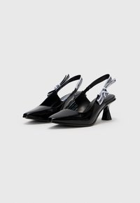 Chaussures slingback en cuir verni noir avec un bout pointu, un talon texturé et des brides de marque contrastantes. Fini lisse, design moderne, silhouette chic.