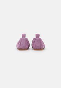 Ballerine in suede rosa con punta arrotondata, texture morbida e tacco piccolo. Presentano un linguetta sul retro per facilitarne l'indosso e dettagli di cucitura lungo i lati.