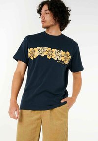 Navyblaue Baumwoll-T-Shirt mit einem gelben Blumenmuster auf der Brust, darunter der Markennamen "RIP CURL".