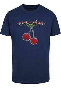 Jūras zils kokvilnas T-krekls ar divu sarkano ķiršu grafiku un uzrakstu "Kings of Leon". Īsām piedurknēm un apaļu kakla izgriezumu.