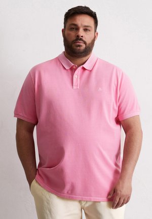 Polo shirt rose avec un col et des manches courtes, fabriqué en coton. Présente un petit logo sur la poitrine gauche.