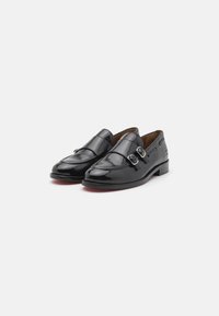 Lofere din piele neagră cu un design elegant, accente cu catarame duble și un finisaj neted și lustruit. Toc joasă și formă rotundă a vârfului.