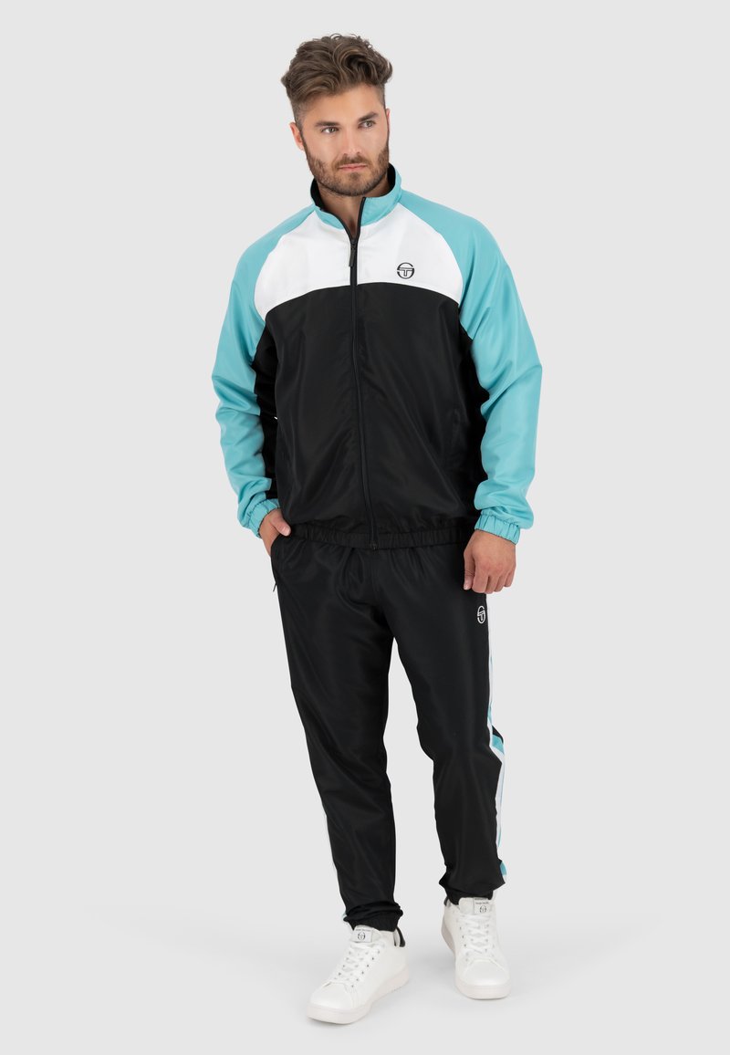 Heren trainingspak in zwart, wit en aqua, met een ritsjack met een staande kraag en elastische tailleband, gecombineerd met bijpassende broek.
