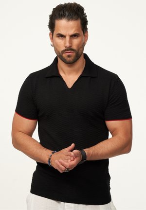 Black textured polo shirt with a V-neck and red accents on sleeves. Short sleeves, fitted design, and ribbed collar.