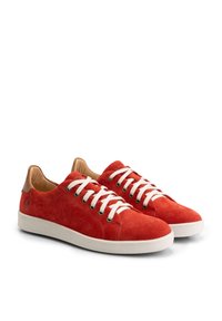 Paire de baskets basses en daim rouge avec lacets blancs et semelles en caoutchouc, ornées d'accents en cuir marron au talon.