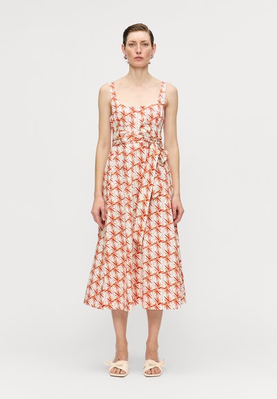 Ärmelloses Midikleid mit einem figurbetonten Oberteil und einem ausgestellten Rock, mit einem weißen Hintergrund und roten Blattmustern sowie einem Bindegürtel in der Taille.