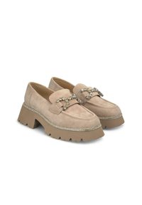 Beige suède loafers met chunky plateauzolen, versierd met een decoratieve kettingaccent en zilveren trim langs de randen.