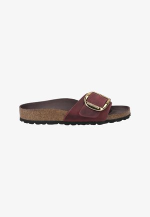 Sandalo slide in suede rosso con plantare in sughero, caratterizzato da una grande fibbia dorata e una suola in gomma nera testurizzata per una migliore aderenza.