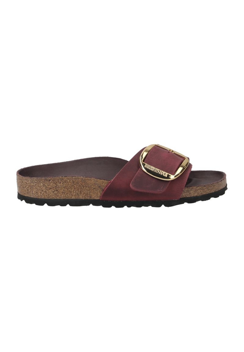 Røde ruskinds slide-sandaler med en korkfodseng, der har et stort guldspænde og en tekstureret sort gummisål for bedre greb.