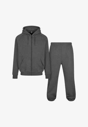 Szürke zipzáras kapucnis pulóver kenguru zsebekkel és hozzáillő melegítőnadrággal. Puha anyagból készült, rugalmas mandzsettákkal és elasztikus derékkal rendelkezik.