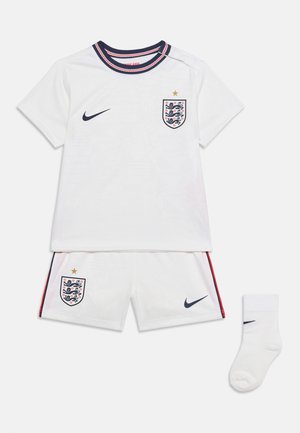 Λευκή εμφάνιση ποδοσφαίρου της Αγγλίας με κοντομάνικο πουκάμισο, σορτς με μπλε σκούρα και κόκκινη επένδυση, και λευκή κάλτσα, όλα με τα σήματα της Nike και της Αγγλίας.