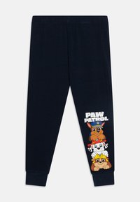 Marineblaue Jogginghose mit weichem Material, versehen mit einer Grafik von drei Cartoon-Hunden aus Paw Patrol am unteren linken Bein.