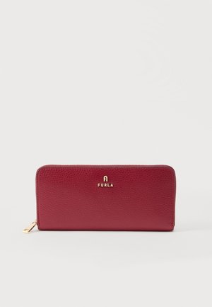 Portefeuille rouge en cuir texturé avec fermeture éclair tout autour, logo Furla doré et tirette, sur fond blanc uni.