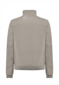 Hellgraue Jacke mit hohem Kragen, langen Ärmeln und geripptem Saum. Glatter Stoff mit subtiler Textur. Keine sichtbaren Verschlüsse oder Akzente.