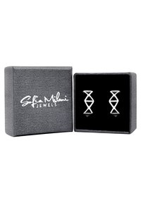 Orecchini geometrici in argento esposti in una scatola regalo foderata in velluto nero con un'esterno grigio testurizzato. Presentano un design intrecciato distintivo.