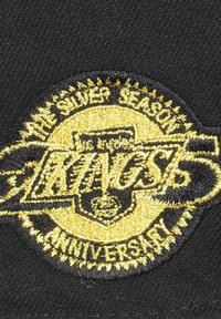Los Angeles Kings gestickter Patch mit schwarzem Hintergrund, goldener Schrift und dekorativen Elementen, der ein silbernes Jubiläum markiert.