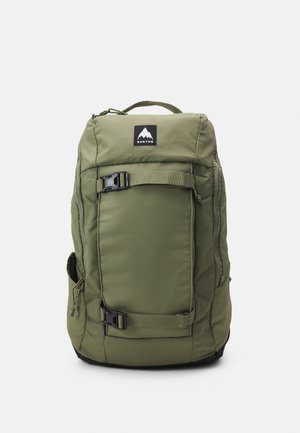 Mochila verde-oliva com forma retangular, bolso frontal com fecho éclair, bolso lateral em rede, alças ajustáveis e detalhes em metal preto.
