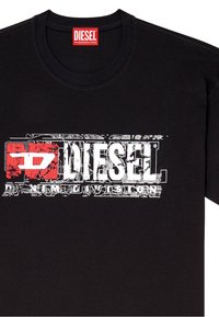 Černé tričko s krátkým rukávem vyrobené z bavlny. Obsahuje červené a bílé opotřebované grafické logo s nápisem "DIESEL" přes hruď. Kulatý výstřih.