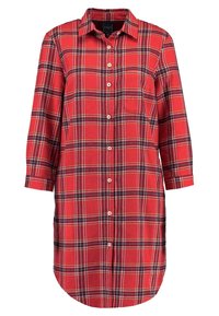 Robe chemise écossaise rouge avec un devant boutonné, un col et une poche poitrine. Elle présente des manches longues avec des poignets retroussés et un ourlet arrondi.