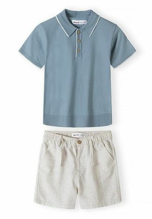 Polo bleu à manches courtes avec boutons en bois, associé à un short beige à taille élastique, avec poches avant et fermeture par bouton.