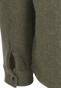 Groen wollen shirt met een gestructureerde afwerking, voorzien van een knoopsluiting op de mouw en een zijsplit voor luchtcirculatie.