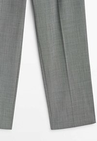 Pantalon gris sur mesure en tissu texturé, avec une coupe droite et un pli devant, se terminant à la cheville.