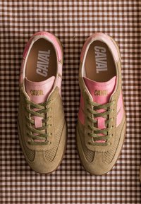 Paire de baskets en daim beige et cuir rose avec des lacets verts, marquage "CAVAL" à l'intérieur et sur la languette, placées sur un tissu à carreaux marron.