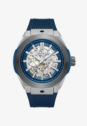 Cerruti 1881-klocka med boett i rostfritt stål, blå gummirem, genomskinlig skeletttavla, detaljer i silver och guld, djärva timmarkörer.