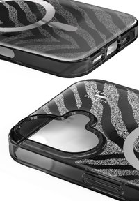 Funda de teléfono negra con rayas de cebra plateadas brillantes y un gráfico circular, mostrada desde dos vistas en ángulo y primer plano.